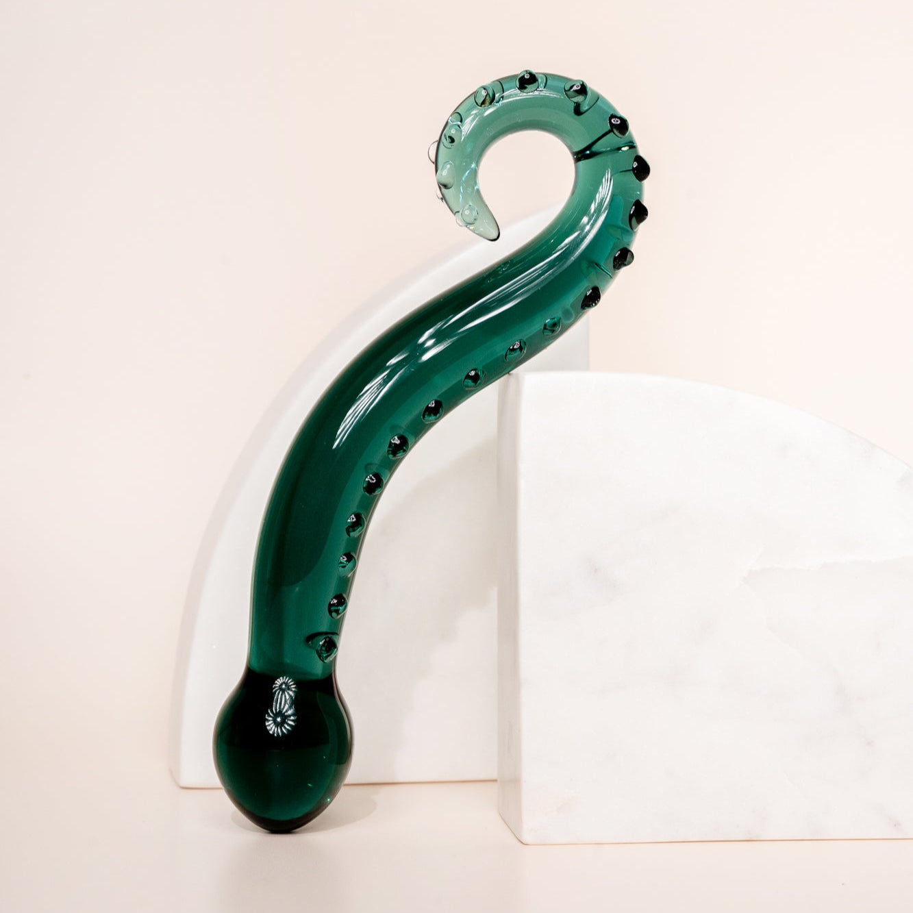 Dark green coloured glass pleasure wand (Octopussy). Pictured on white background with marble coloured arch blocks.