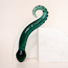 Dark green coloured glass pleasure wand (Octopussy). Pictured on white background with marble coloured arch blocks.