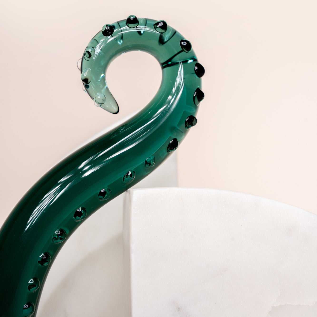Dark green coloured glass pleasure wand (Octopussy). Pictured on white background with marble coloured arch blocks.
